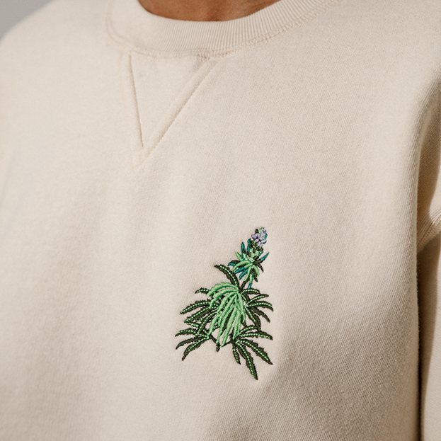 Close up of cannabis embroidery on beige crewneck 