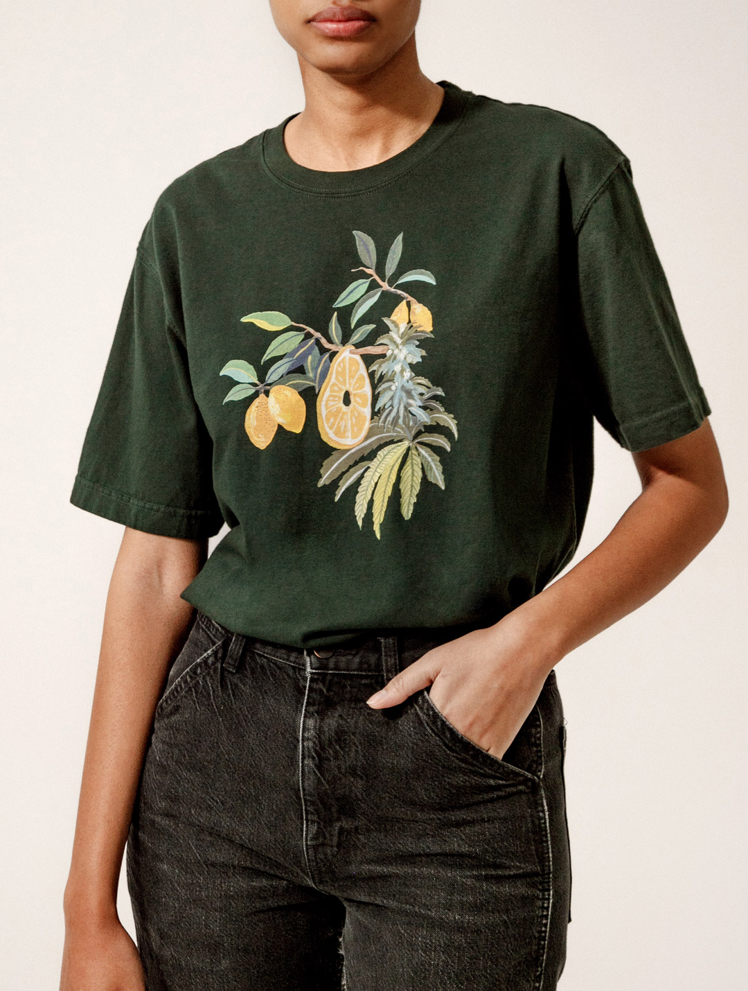 model wearing green t-shirt with lemon and cannabis illustration