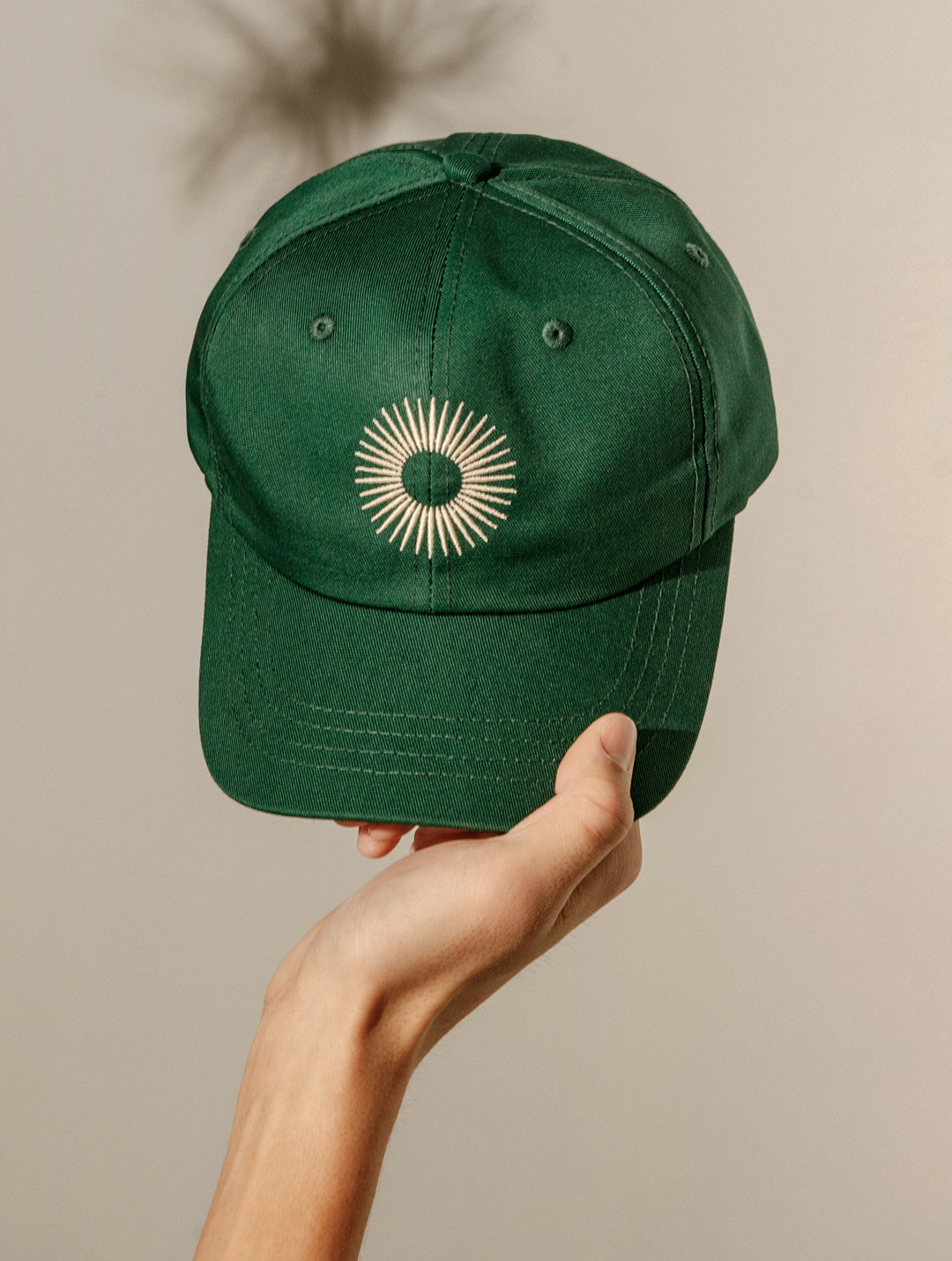 green ball cap with sun logo