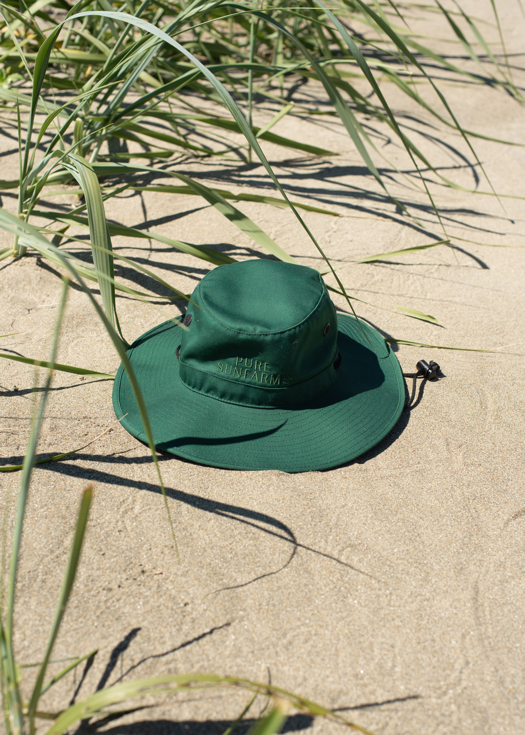 green Growers Hat in the sand