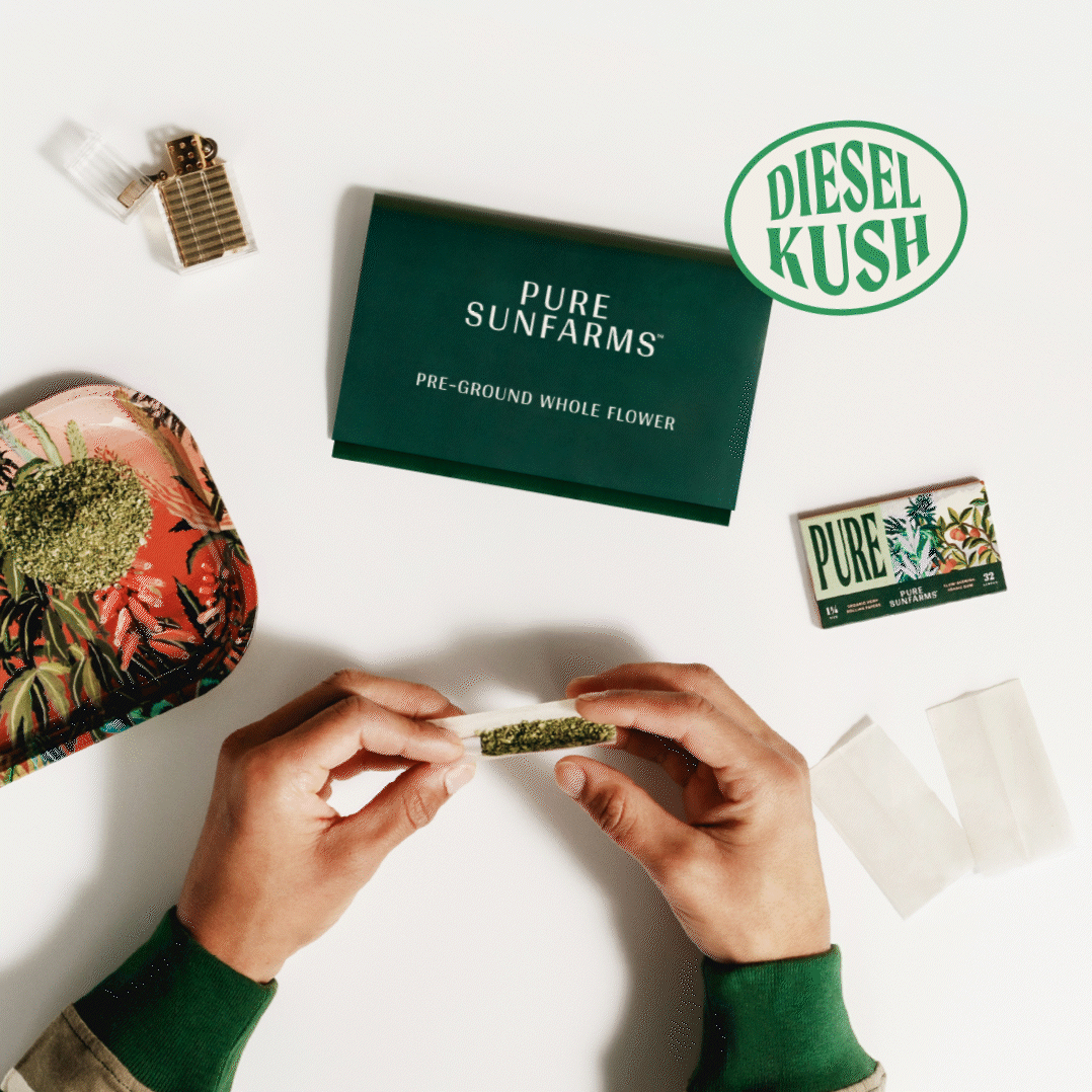 Hands rolling a joint with  Diesel Kush preground. Tray, packaging and paper in the picture. 
