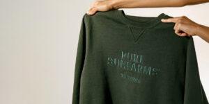 green crewneck sweater with Pure Sunfarms logo