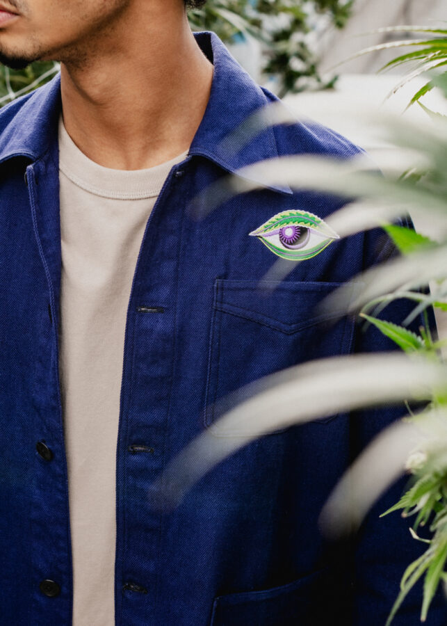 Model wearing Black Cherry Punch work shirt in greenhouse with cannabis plants