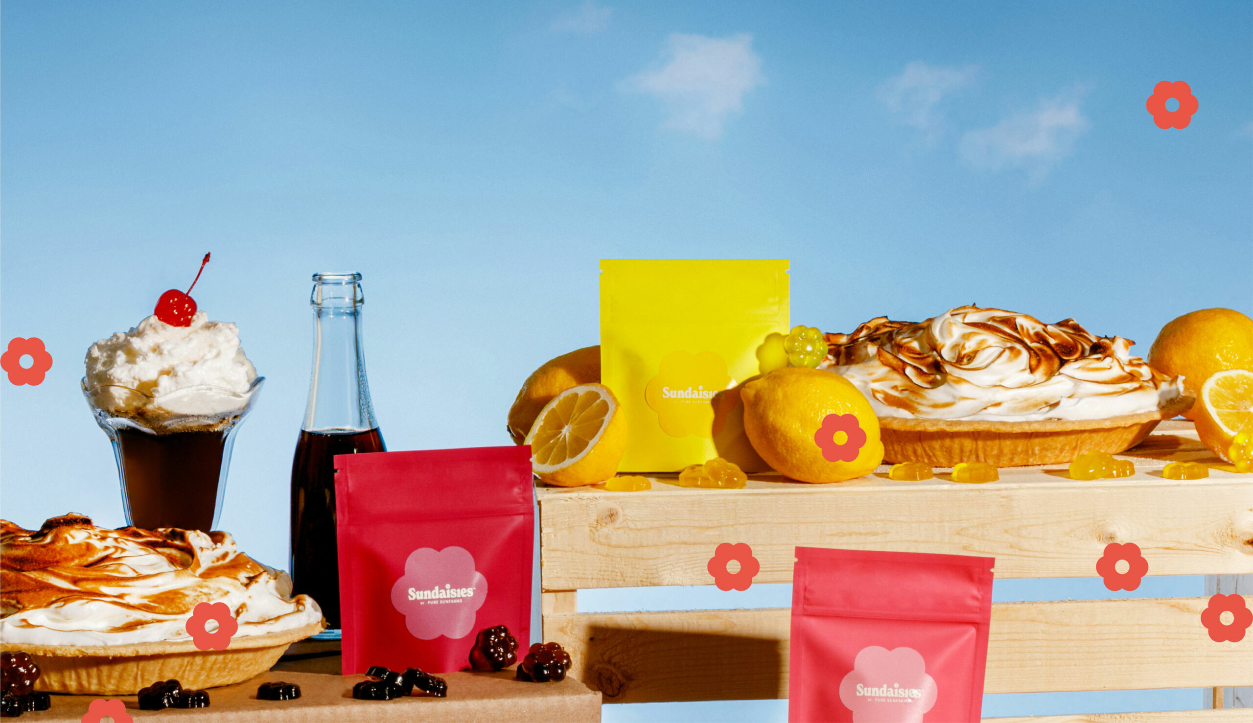 Picnic setting with fruits, pie, gummies and Sundaises packaging.